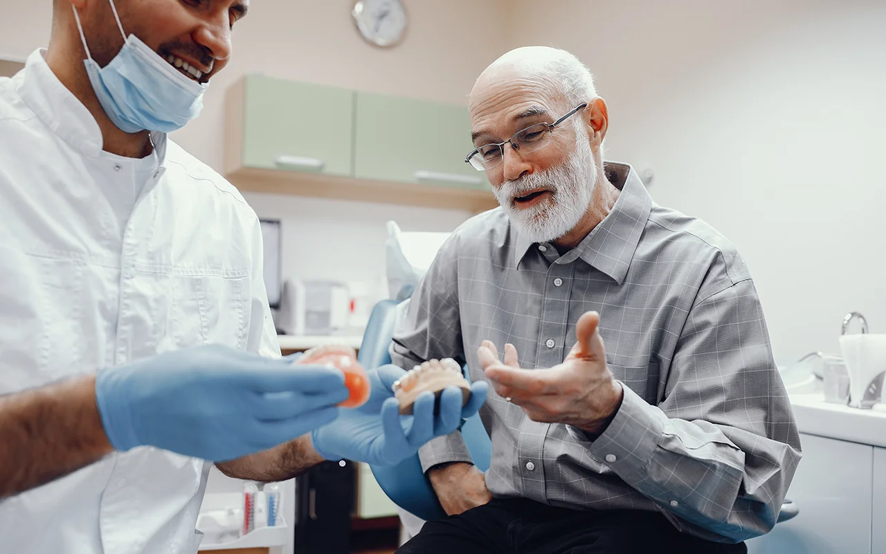 Paciente a analisar a prótese com o dentista